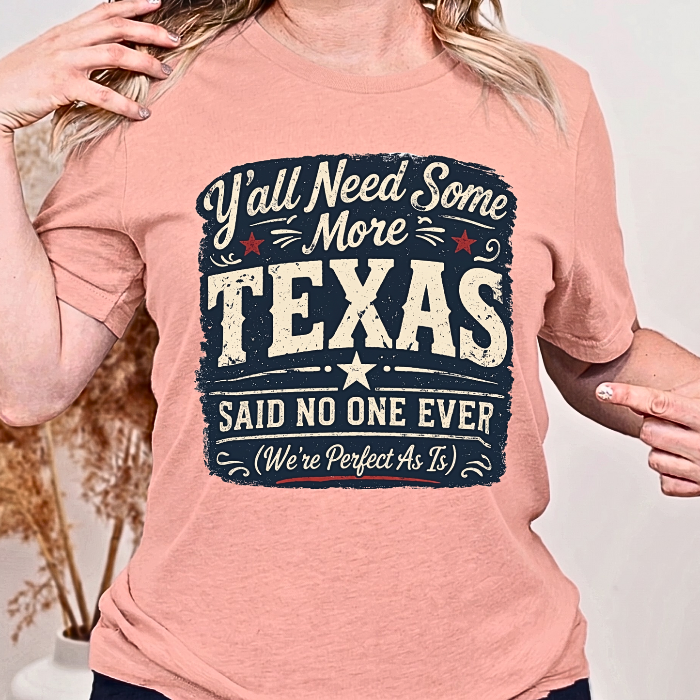 Person wearing a pink t-shirt with a Texas-themed graphic design.