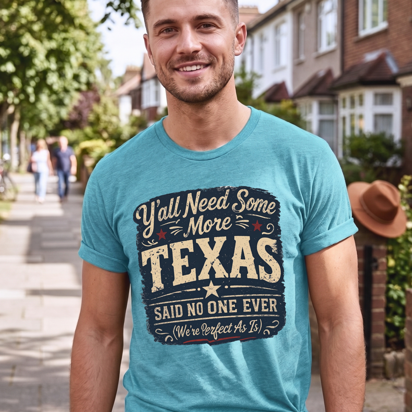 Man wearing a turquoise t-shirt with 'Y'all Need Some More Texas' text on a residential street.