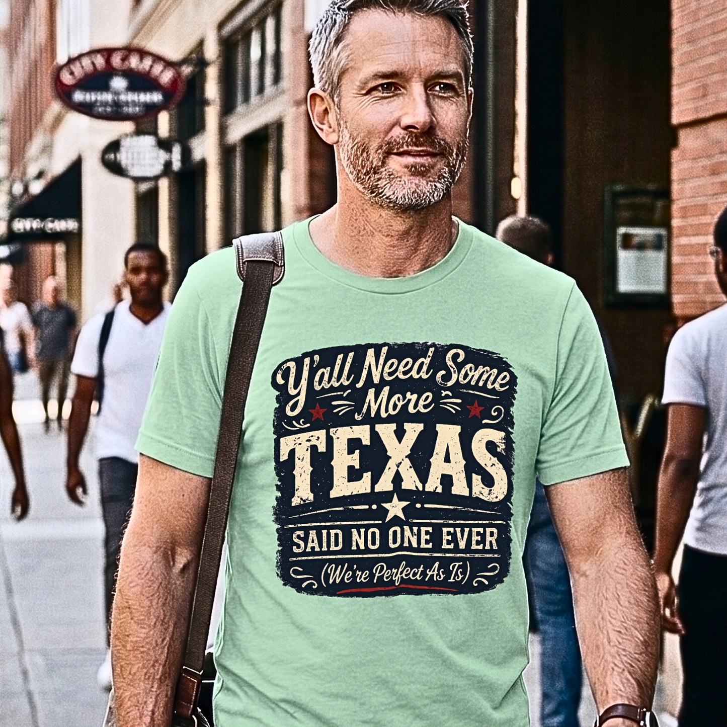 Man wearing a green t-shirt with a humorous Texas slogan on a city street.