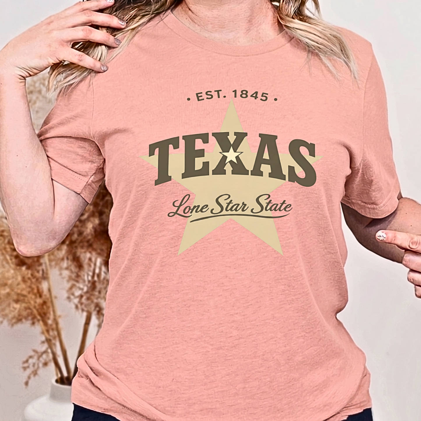 Person wearing a pink t-shirt with 'Texas' and star design.