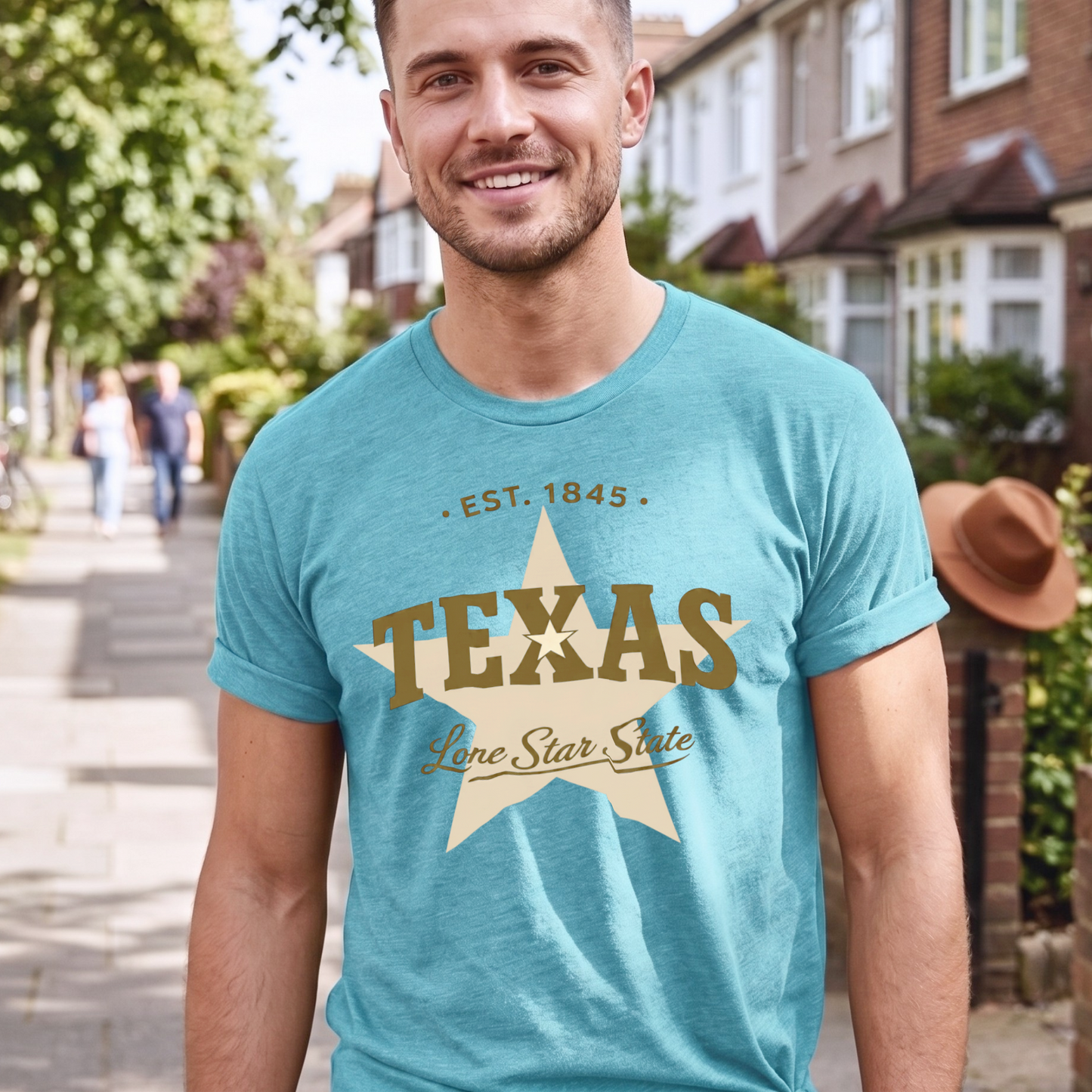 Man wearing a turquoise blue t-shirt with 'Texas' design standing on a residential street.