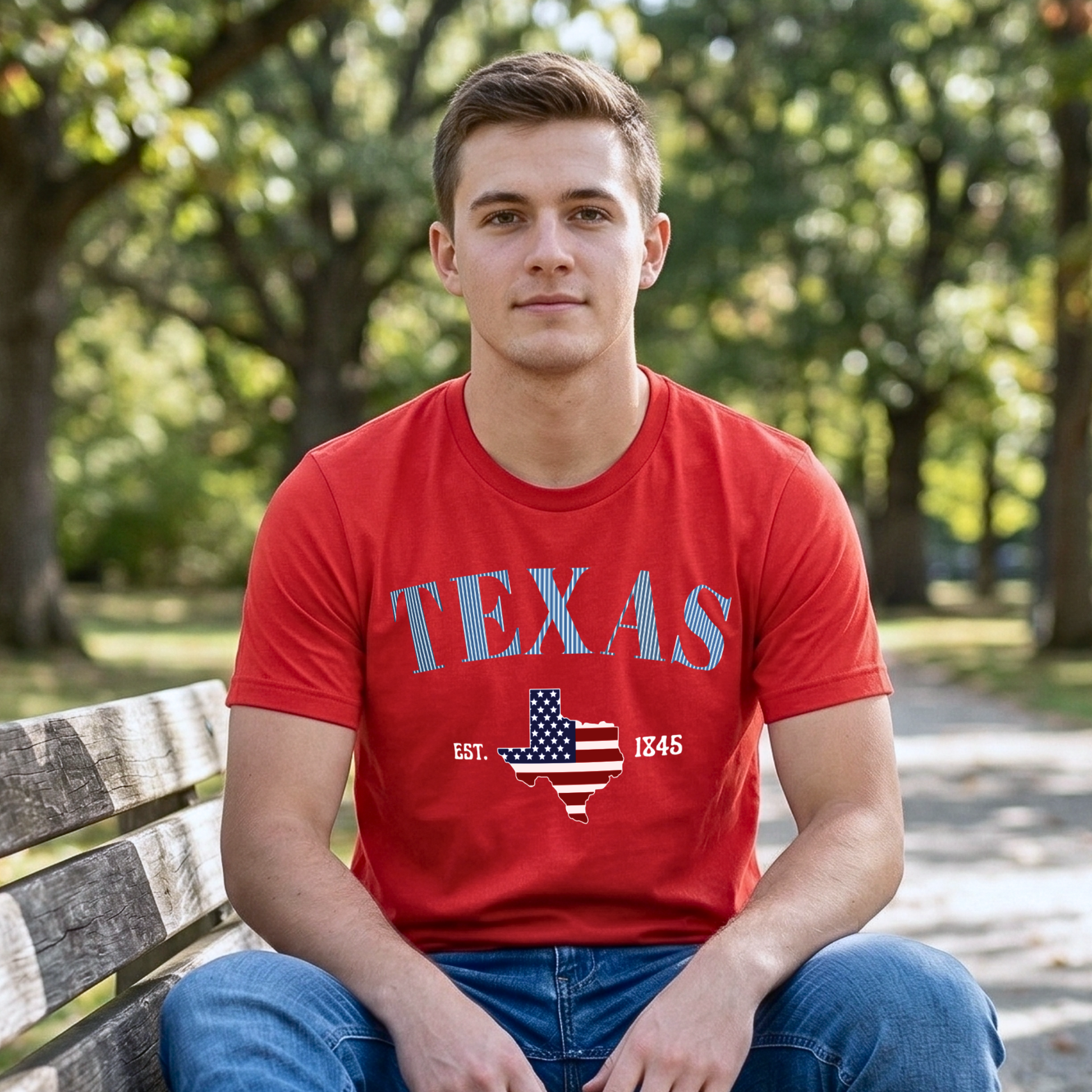 Man wearing a red 'TEXAS' t-shirt with a map design, sitting on a bench outdoors.
