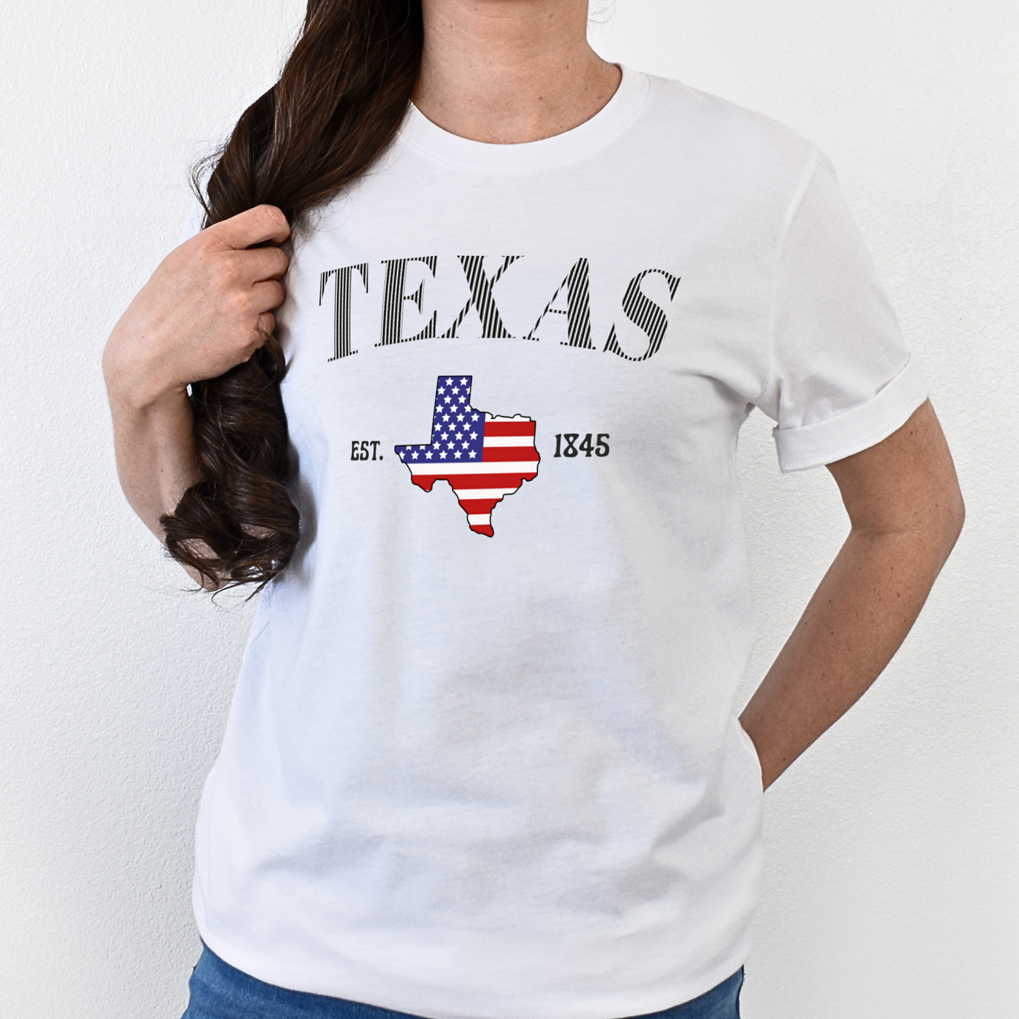 Person wearing a white t-shirt with 'TEXAS' and a map design on a plain background